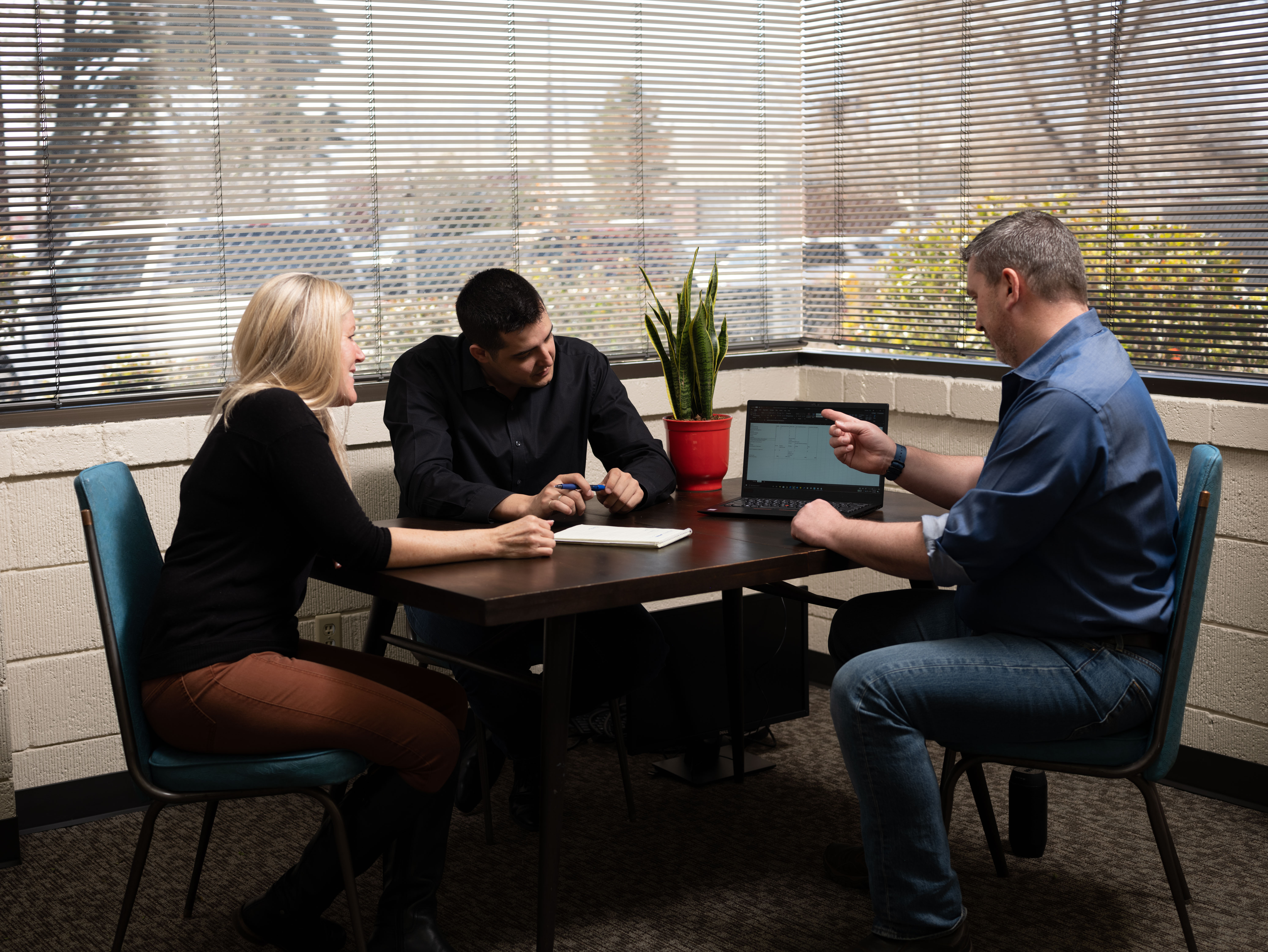 Sierra Miles team members huddle around a laptop in their Reno office.