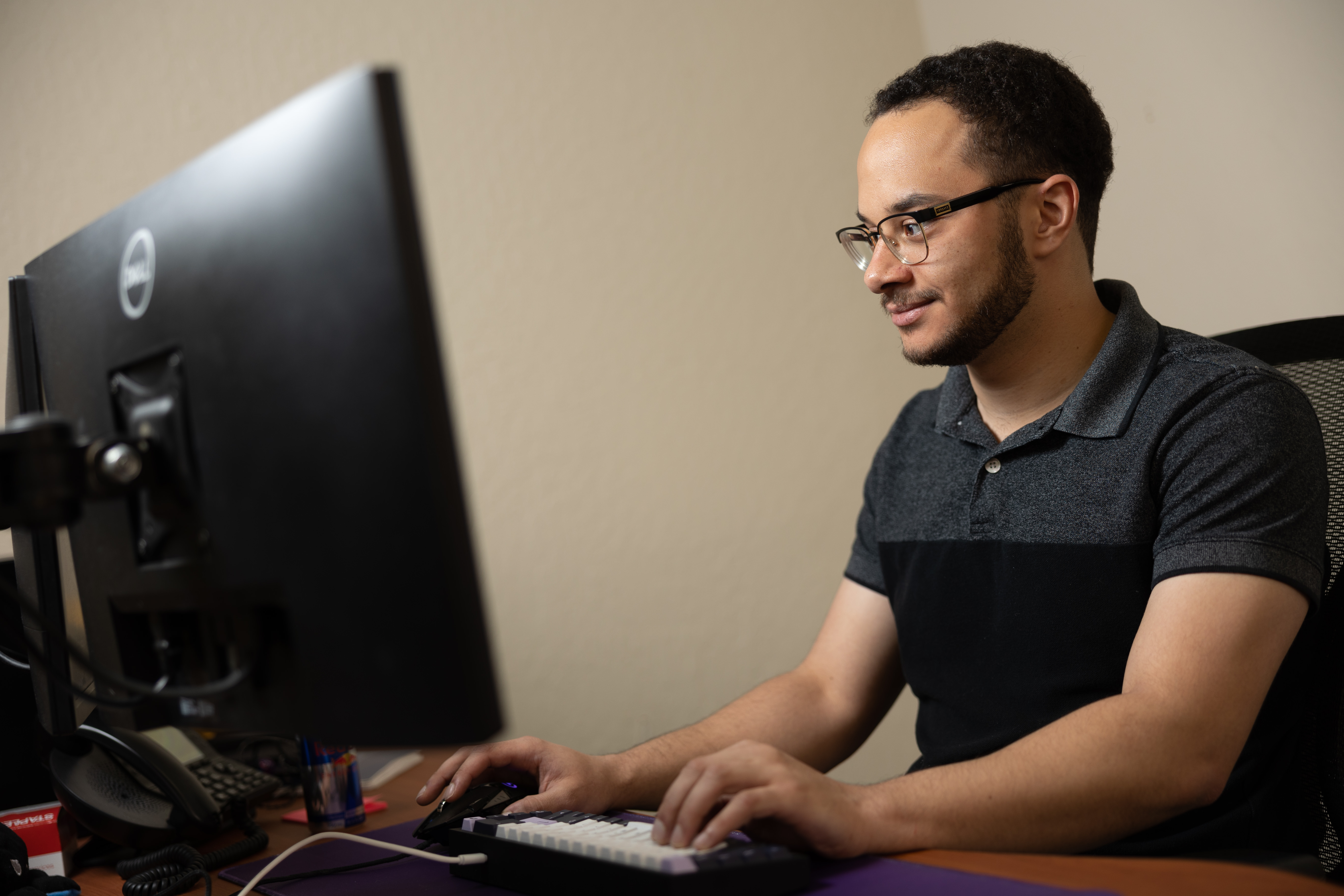 IT technician Isiah troubleshooting software at his workstation