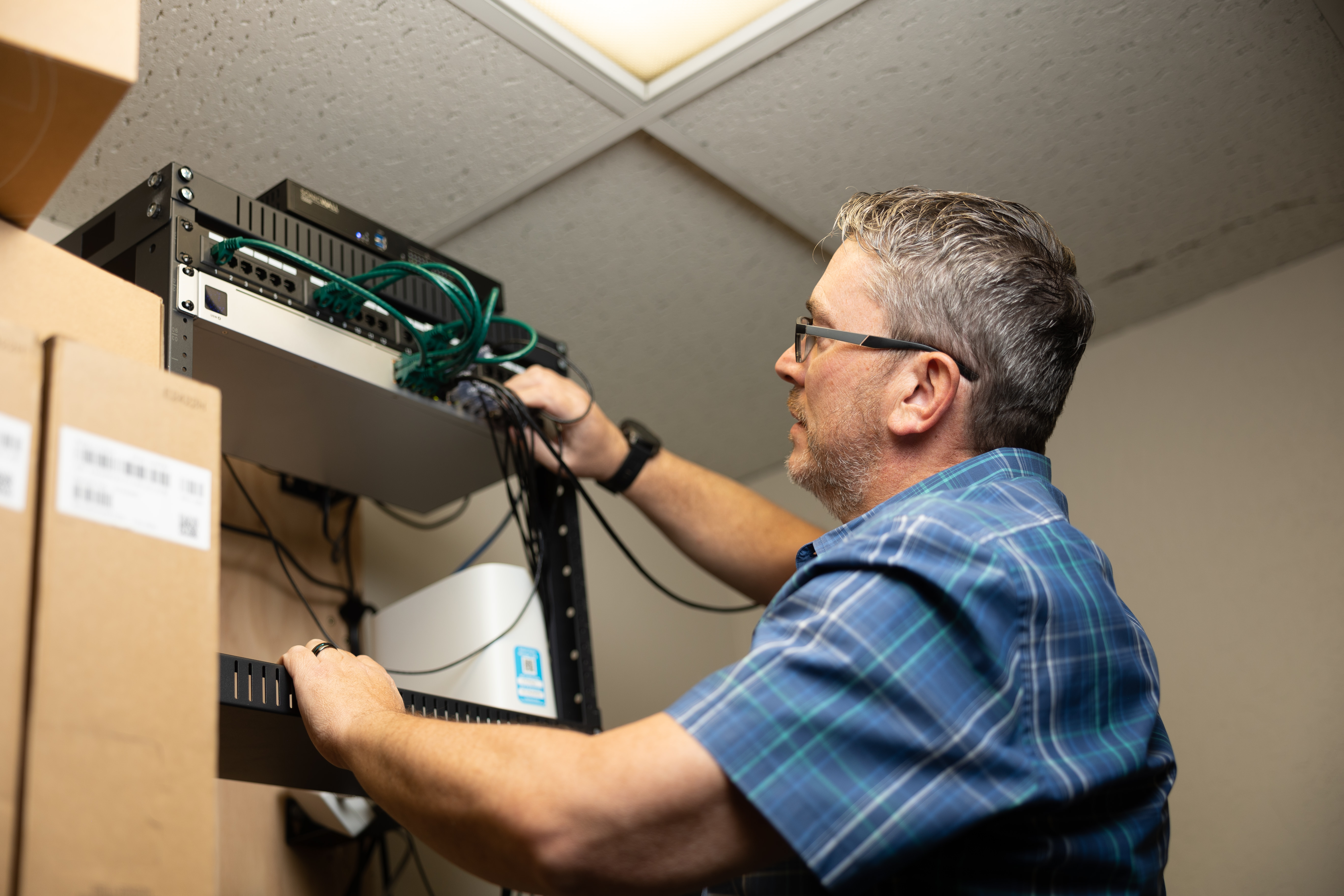 IT professional installing network equipment in office server rack