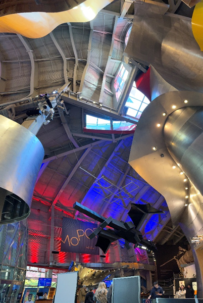 Interior view of MoPOP, featuring its iconic, futuristic architecture with flowing metallic structures and vibrant lighting, reflecting the museum's focus on contemporary pop culture.