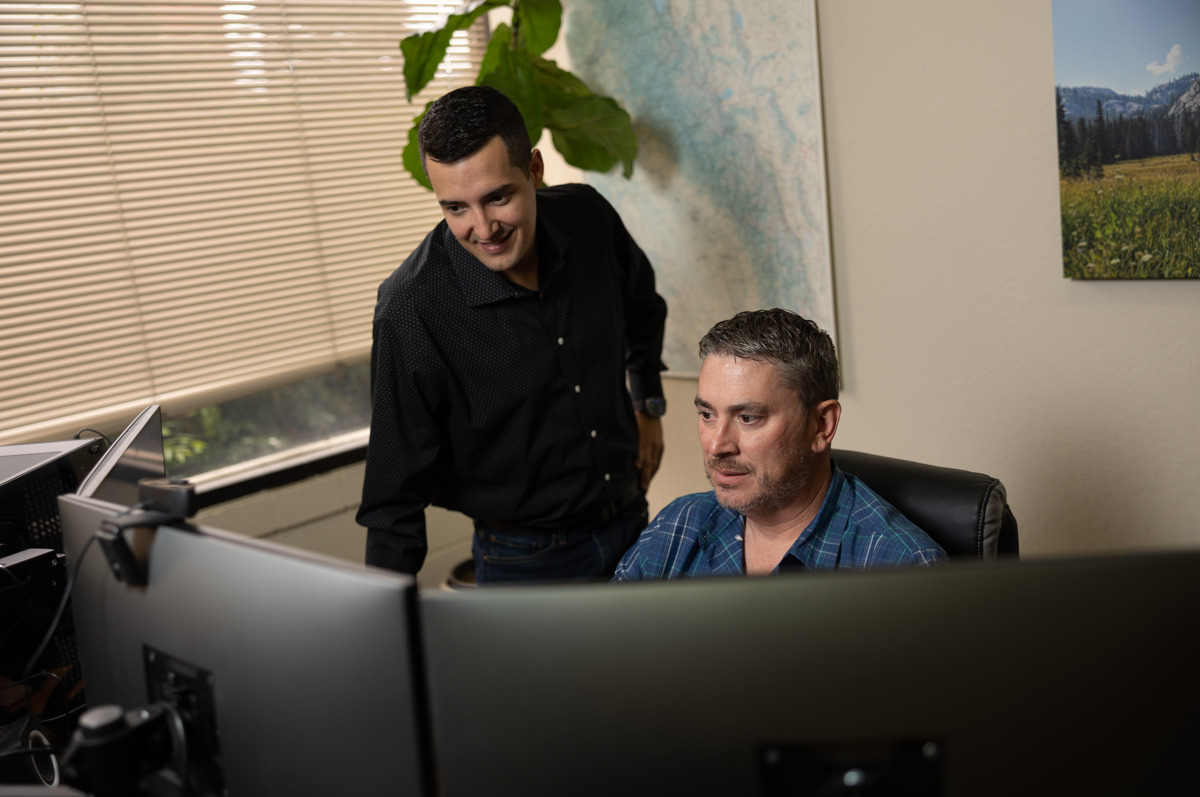 Senior IT technician Tim and manager Brandon evaluating new tech solutions at their workstation