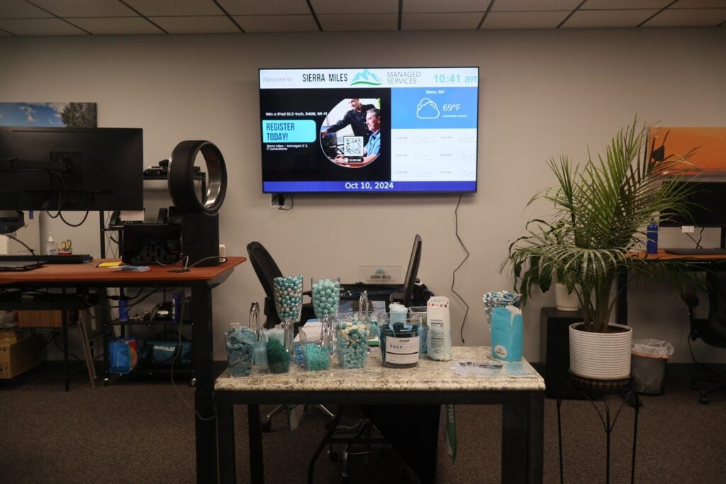Sierra Miles Reno office interior with Managed Services welcome screen and workstations